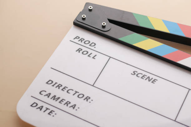 Movie clapper board against yellow background .